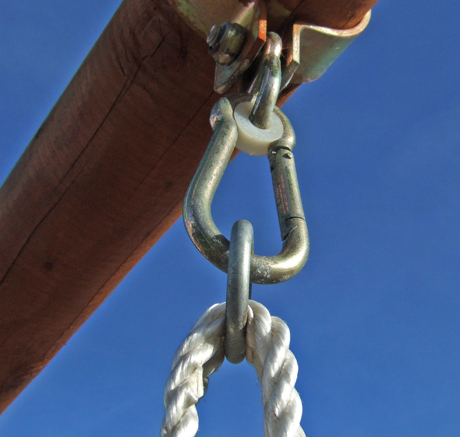 Ein Seil ist über einen Karabiner mit einem Balken verbunden.